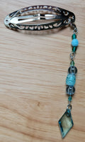 Handmade silver filigree hair clip with teal and aqua beaded chain and faceted teal diamond pendant