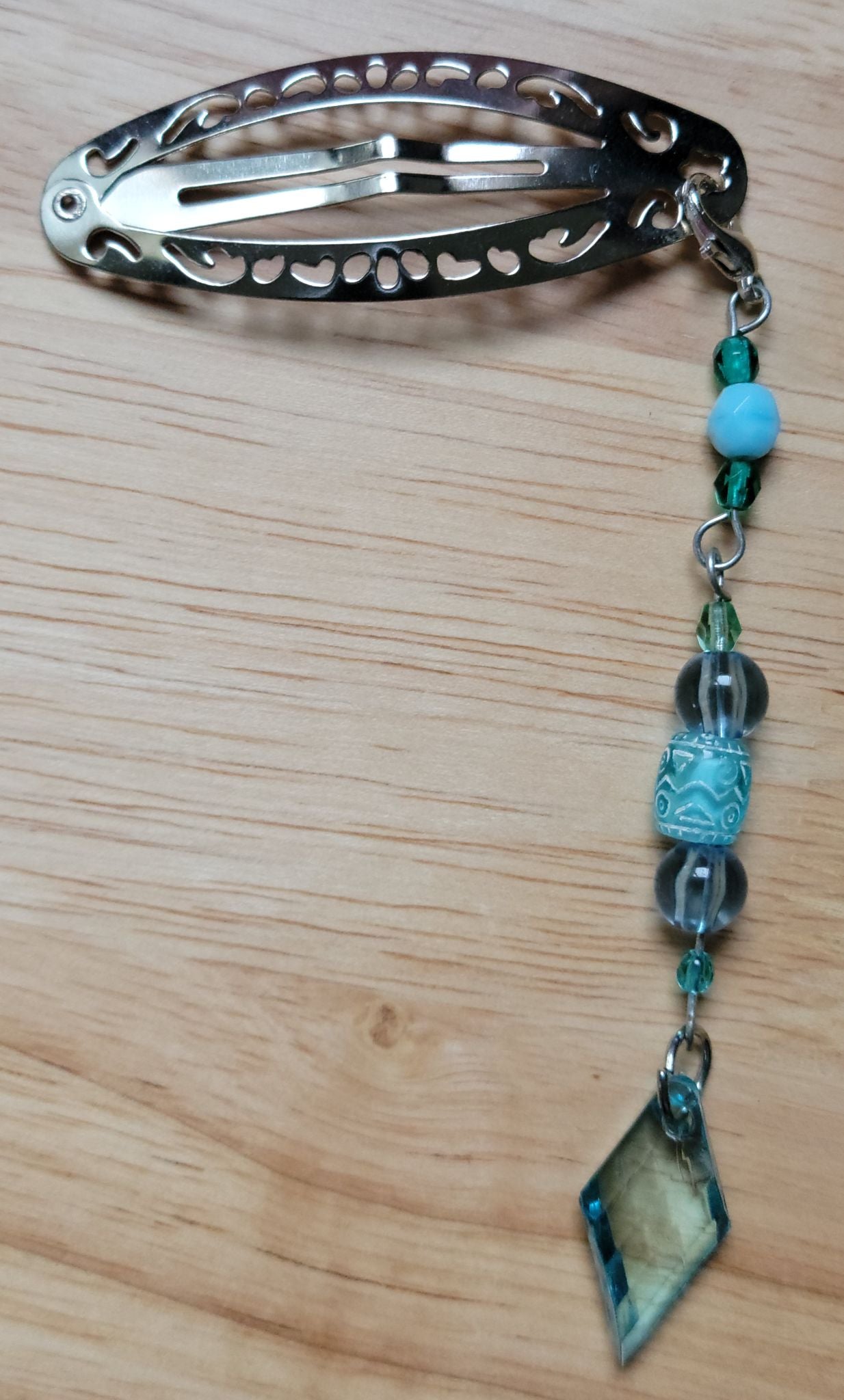 Handmade silver filigree hair clip with teal and aqua beaded chain and faceted teal diamond pendant