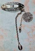 Handmade silver filigree hair clip with ornate medallion, rose bead, and black oval stone pendant drops